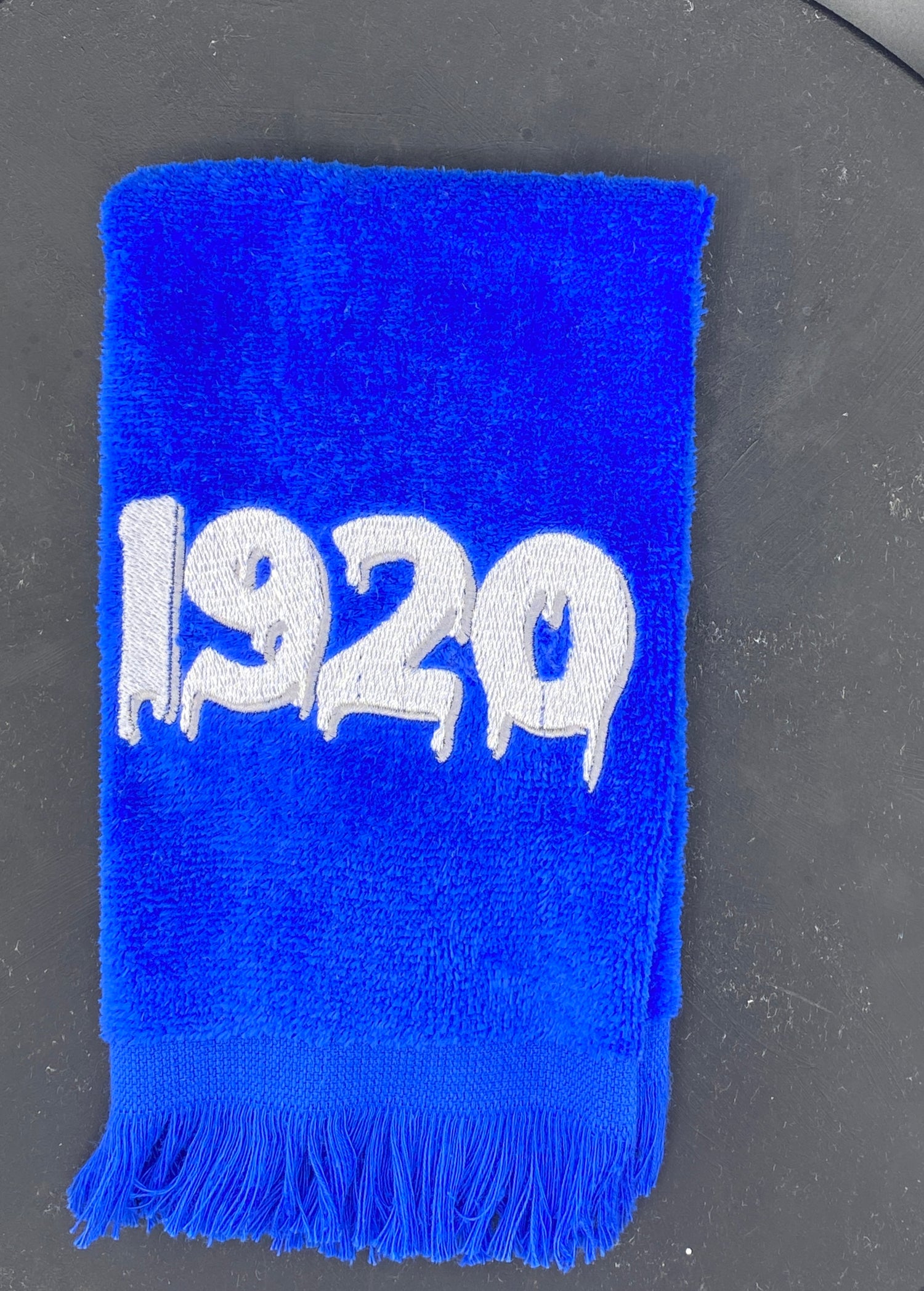 Royal Blue plush velour towel embroidered with a dripping 1920 in White with silver accent.