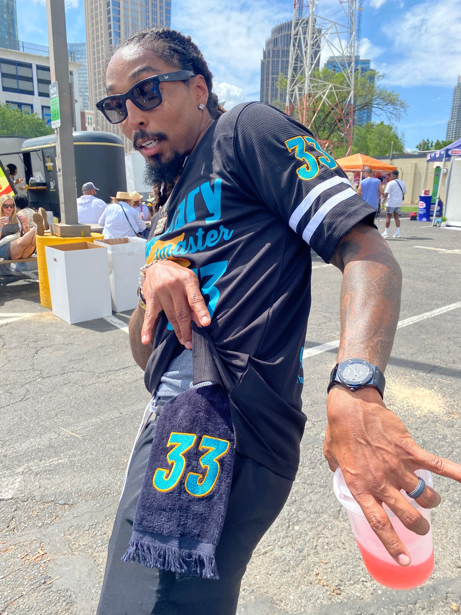 Carolina Panther's Tre Boston in a custom West & Remount printed and embroidered football jersey and Leisure Luxe Towel as the Carolina BBQ Festival PittMaster.