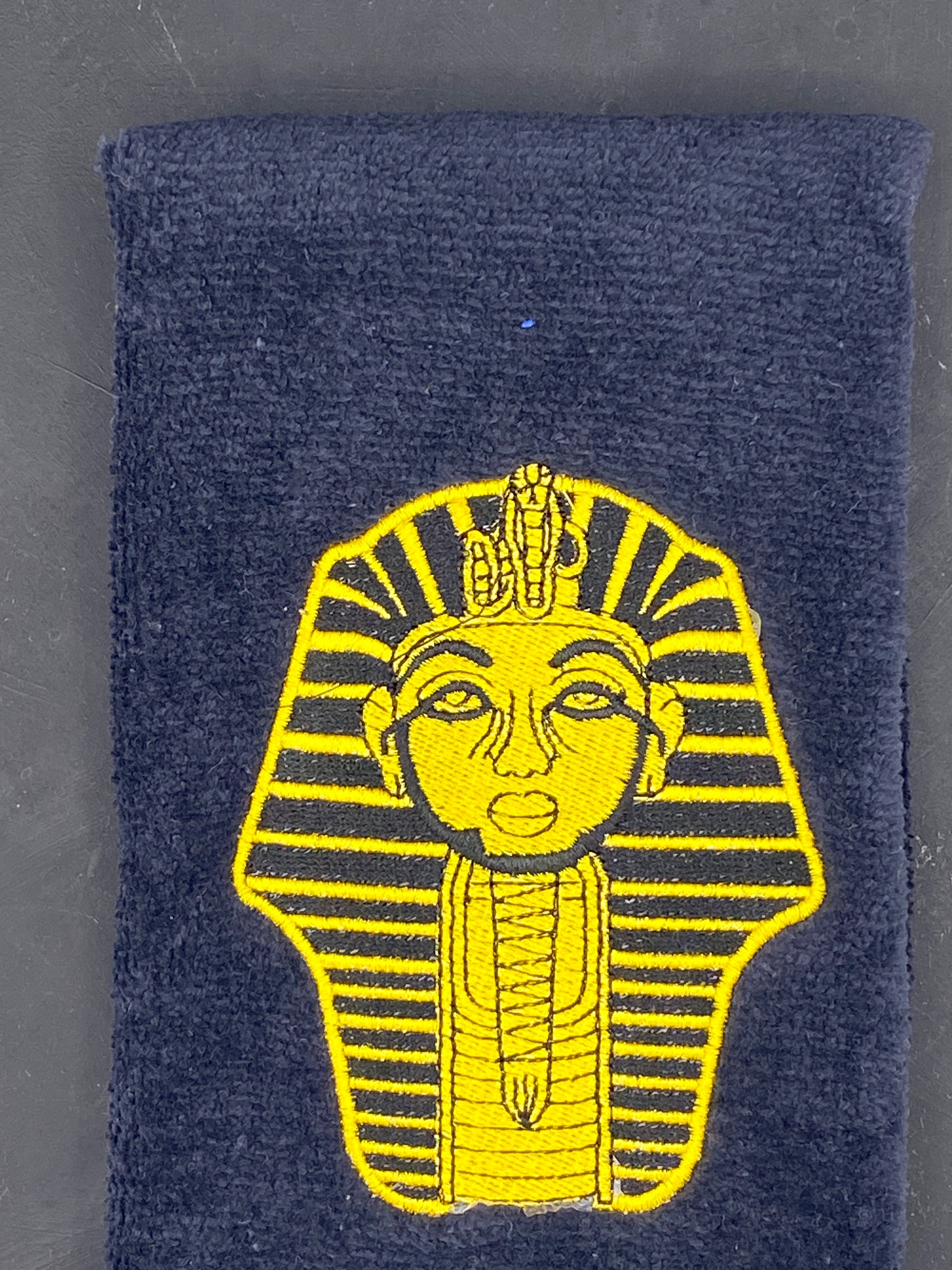Alpha Phi Alpha Sphinx Stroll Towel in Yellow Gold on a plush velour black towel