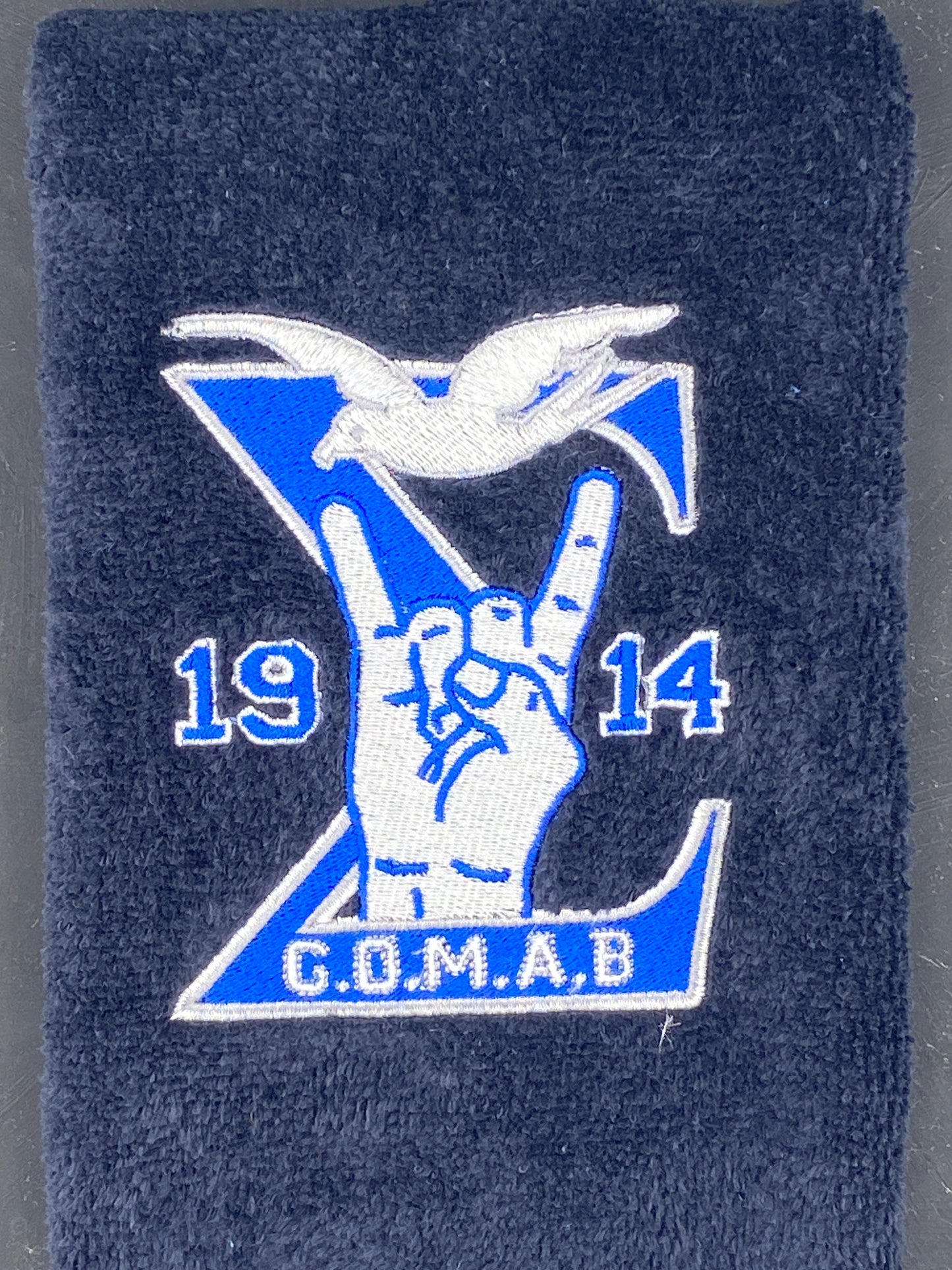 Black Stroll Towel with a Sigma, 1914, handsign, dove and GOMAB embroidered in royal blue, while and silver. 