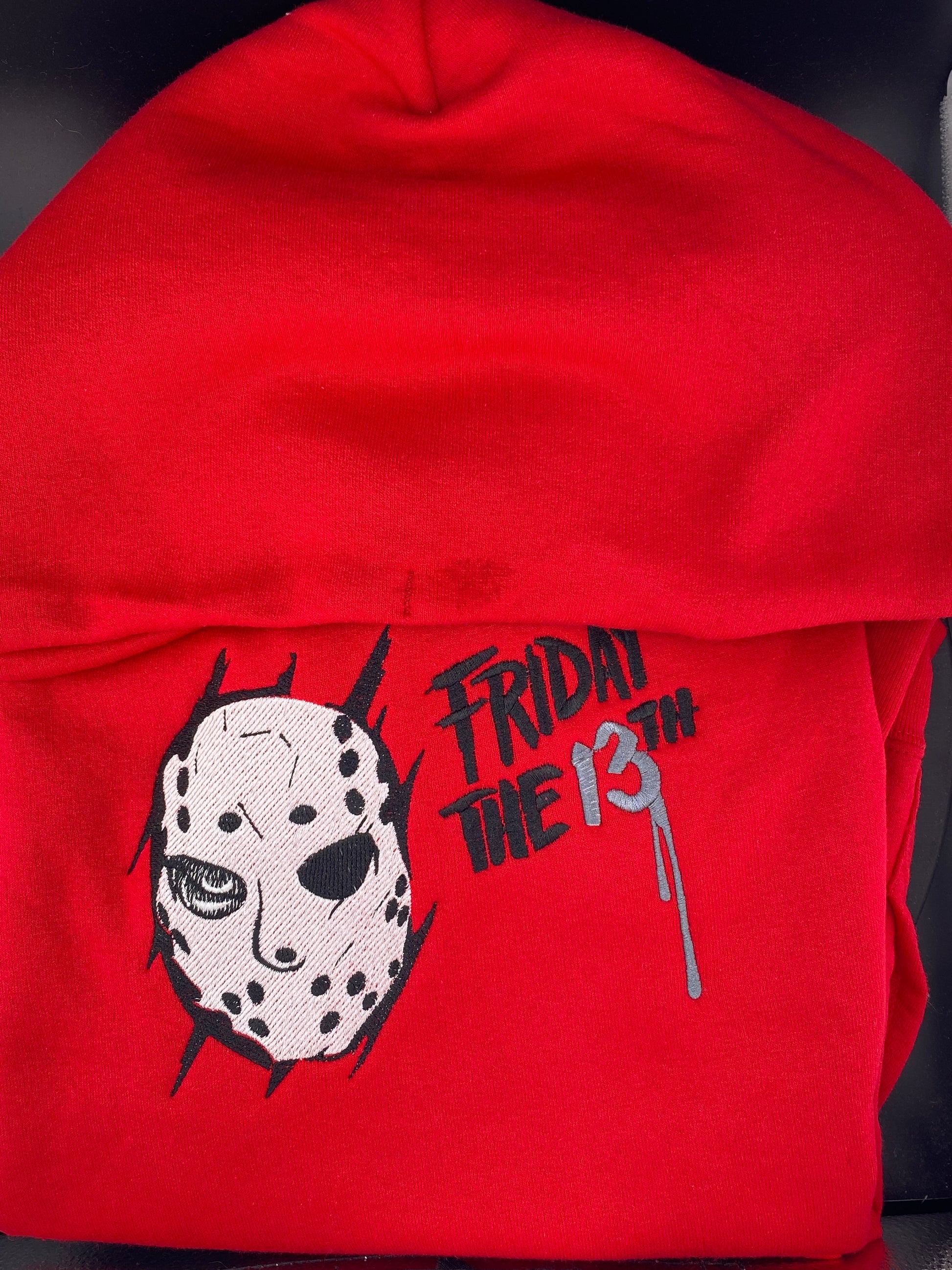 Red hoodie with a Jason Voorhees -inspired embroidery design and the text "Friday the 13th" in black and charcoal gray