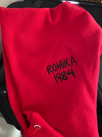 Personalization on the hood of a red hoodie. Features a halloween themed font. 
