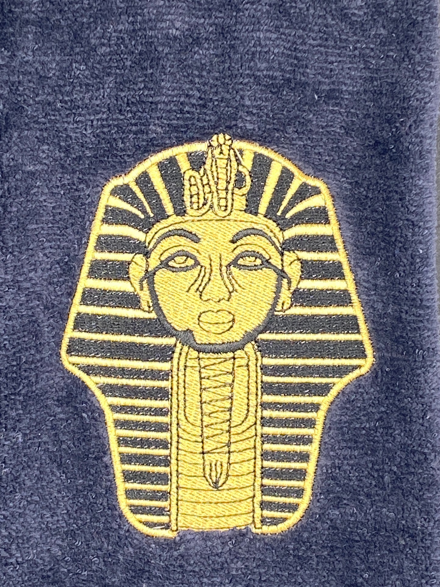 A closeup view of the embroidered Satin Gold Sphinx on our Alpha Phi Alpha Sphinx Stroll Towel
