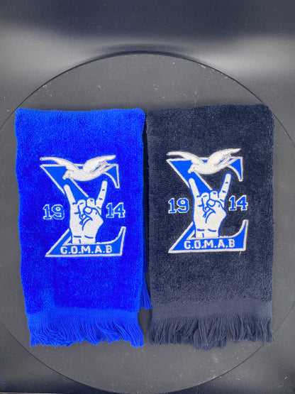 Black and royal blue Stroll Towel with a Sigma, 1914, handsign, dove and GOMAB embroidered in while and silver.  